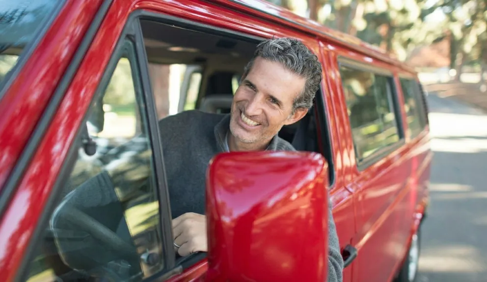 Professional driver leaning on a shuttle van window